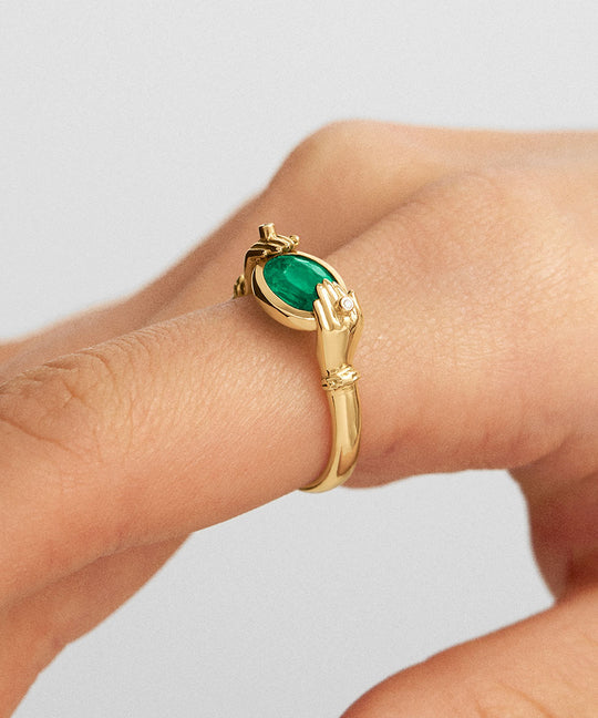 Modelo usando anel de mãos em ouro 18k adornado com diamantes e esmeralda oval
