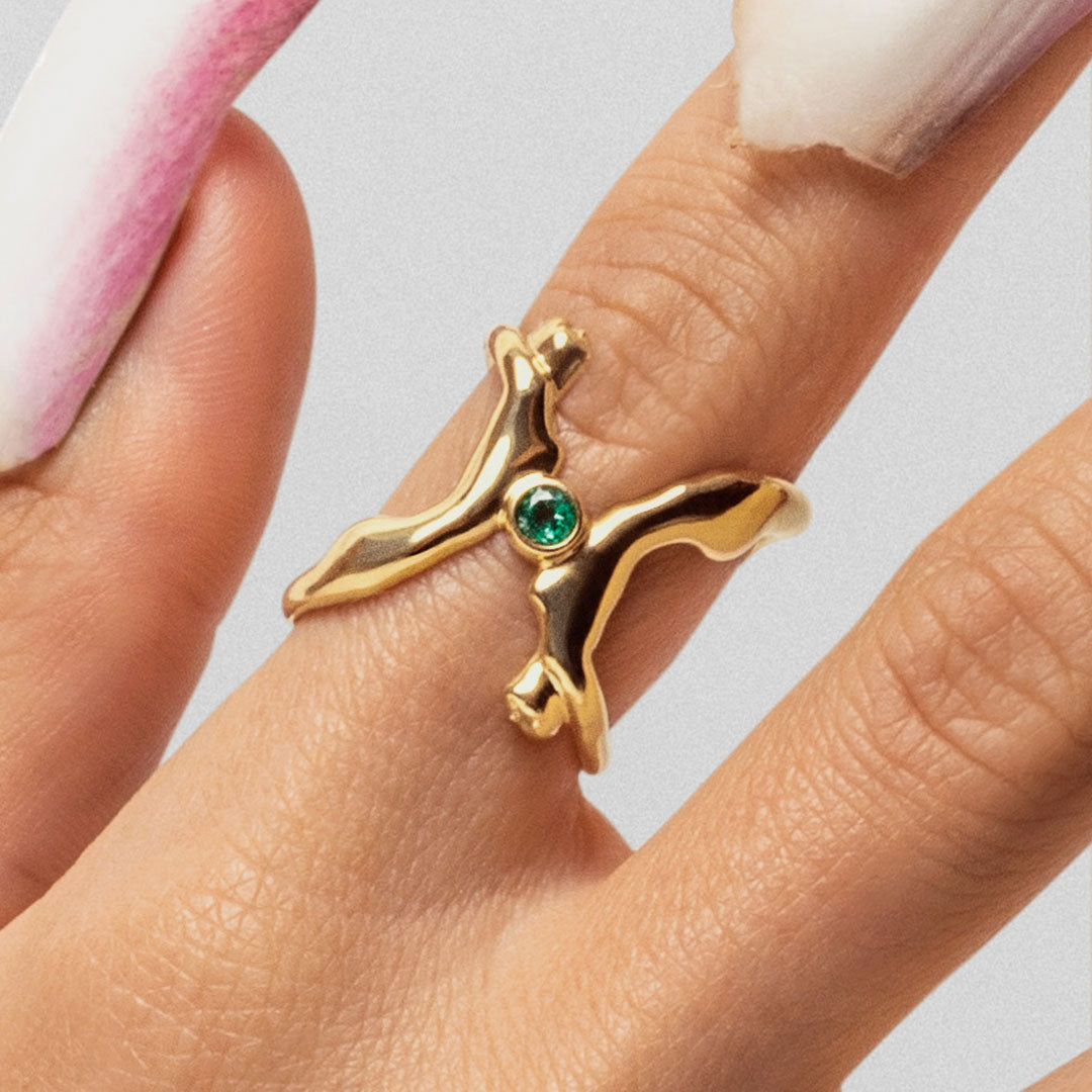 Modelo usando anel em ouro 18k de corpos adornado com esmeralda