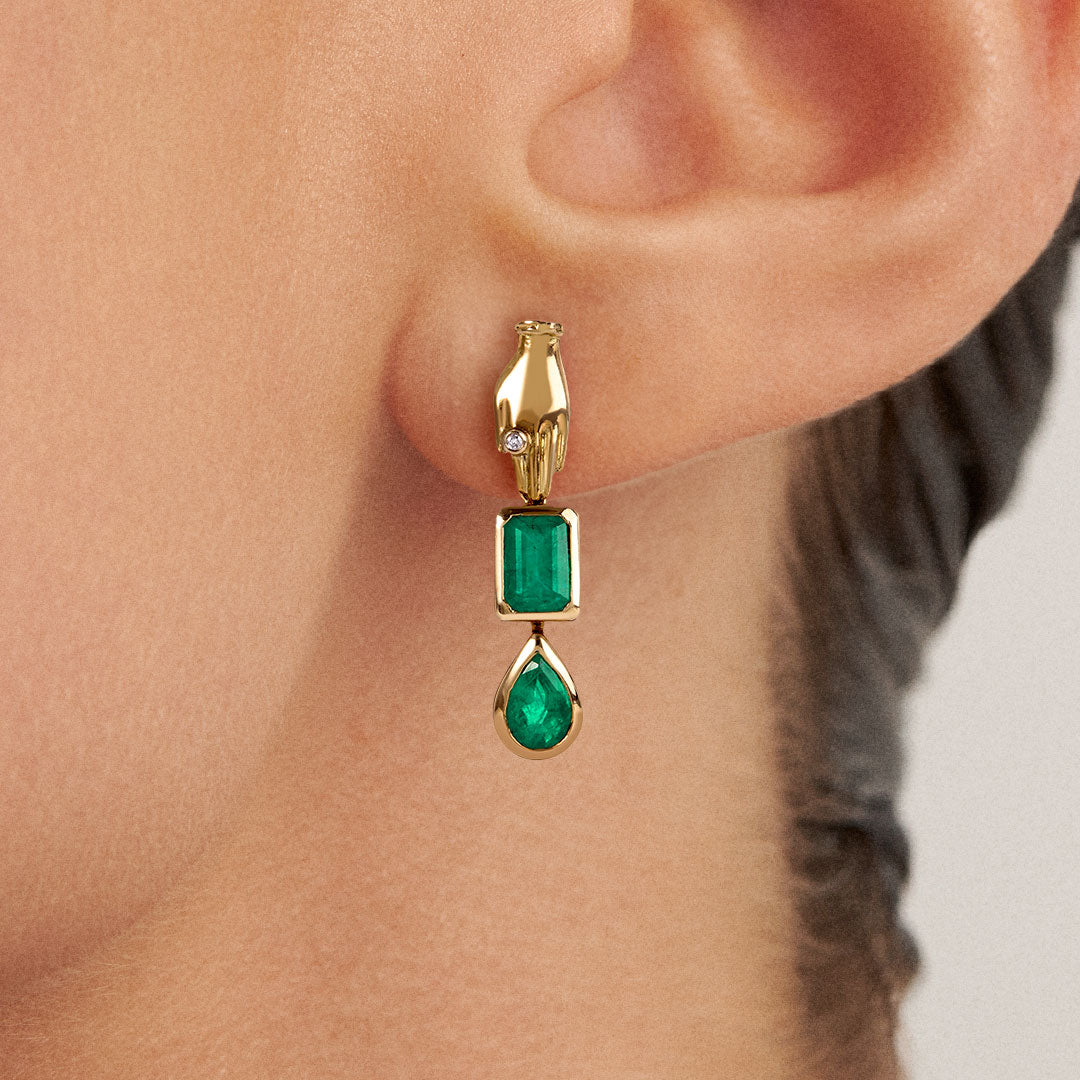 Modelo usando brinco em ouro 18k de mão adornada com esmeraldas e diamante