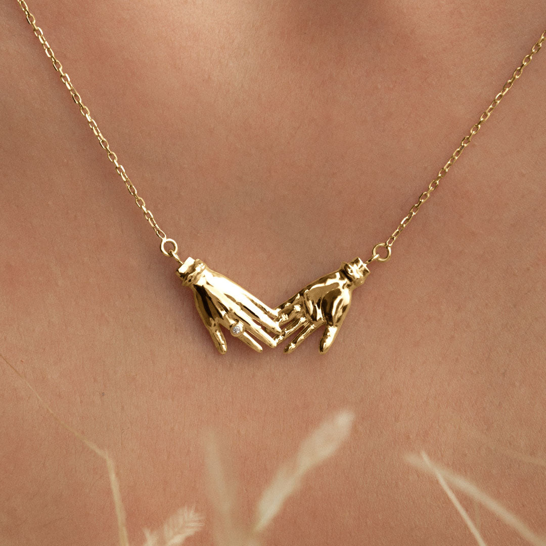 Modelo usando colar em ouro 18k de mãos adornado com diamante