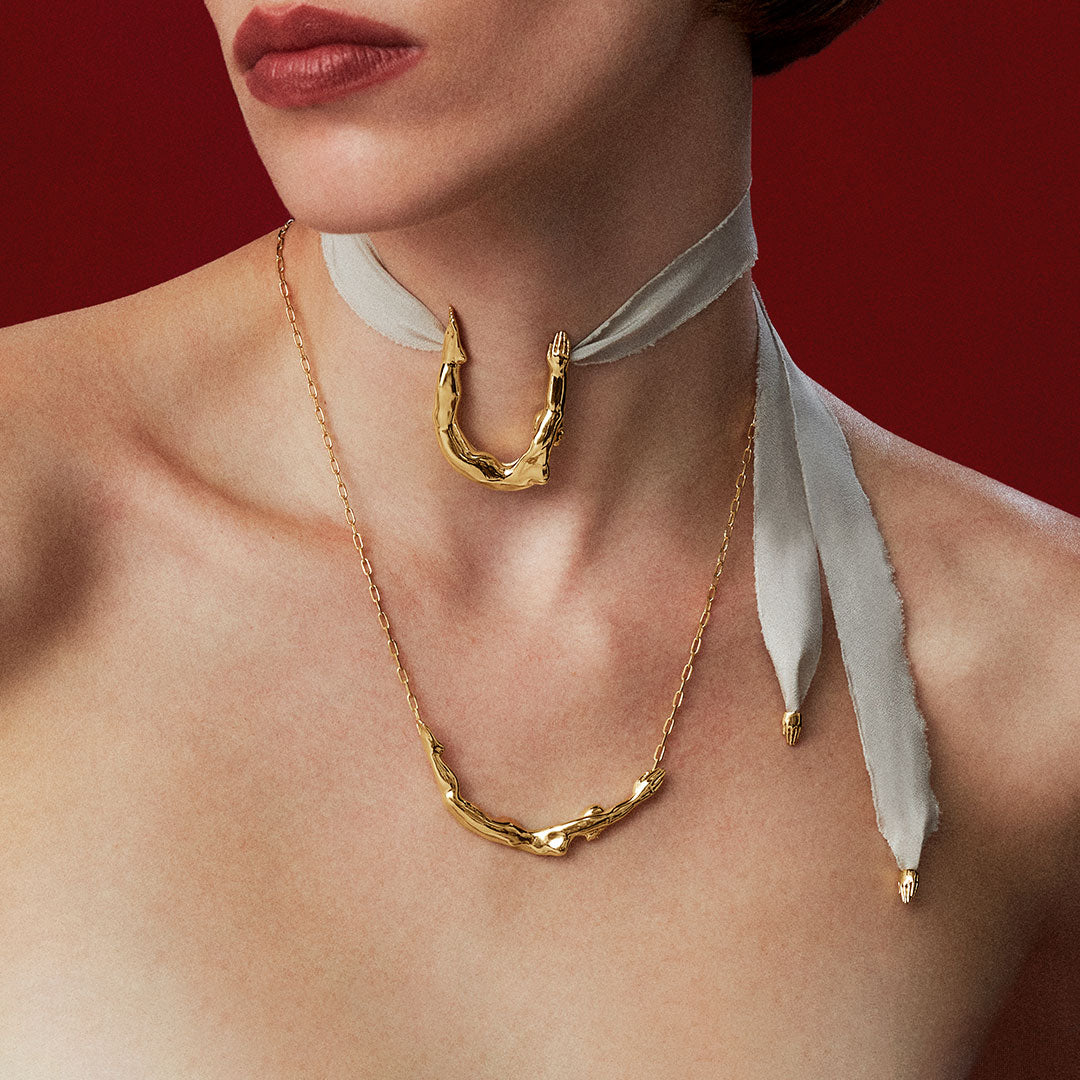 Modelo usando colares em prata 925 com banho de ouro de esculturas de corpos femininos